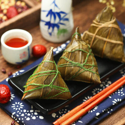 Chinese dragon boat festival rice dumplings zongzi and wine on black plate